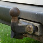 Close-up van een roestige trekhaak onder de achterbumper van een auto