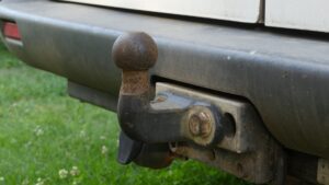 Close-up van een roestige trekhaak onder de achterbumper van een auto