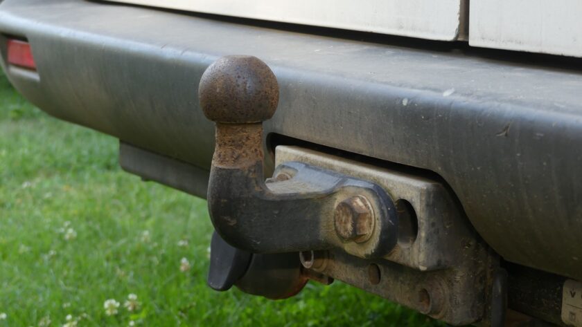 Close-up van een roestige trekhaak onder de achterbumper van een auto