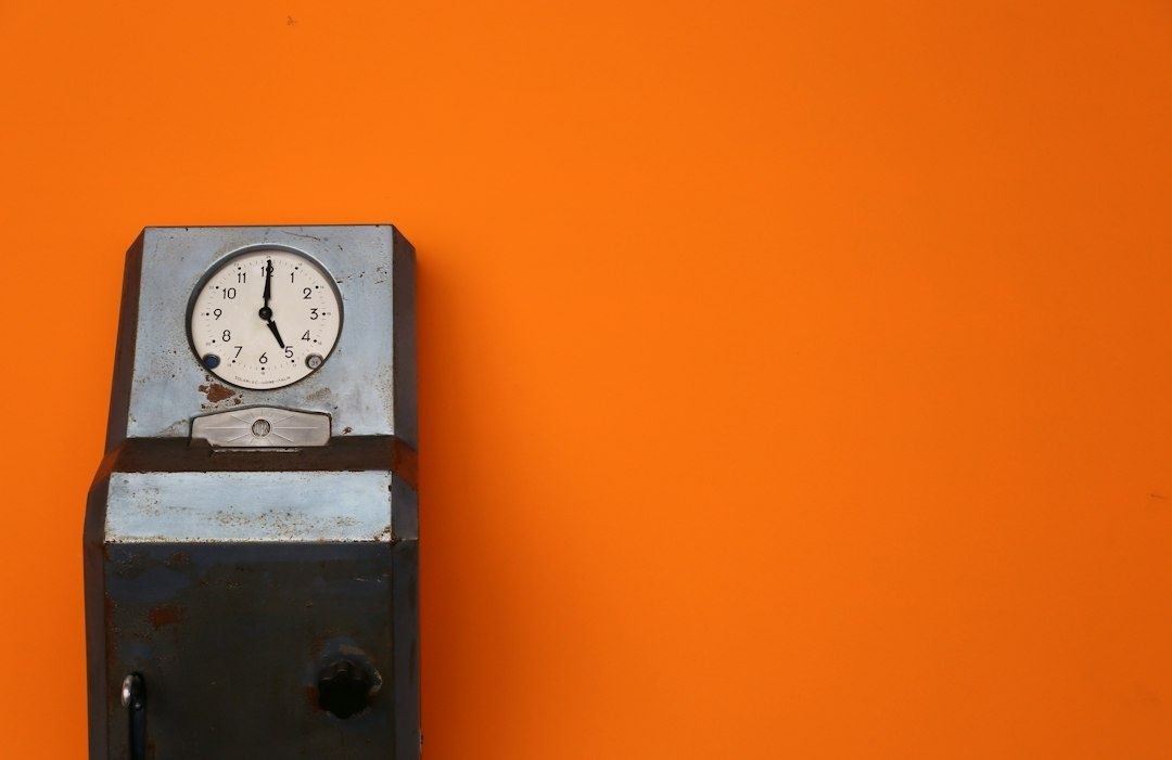 Oude analoge meter tegen een feloranje wand